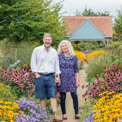 Stephen and Jane Baughan, in the 68-metre-long herbaceous border Stephen has created outside their business, Aston Pottery. The flowers inspire motifs on their pottery.